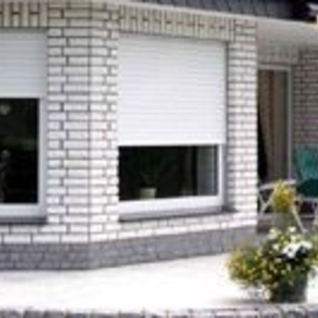 halb aufgerollte Rollläden an Fenstern eines Hauses im Außenbereich